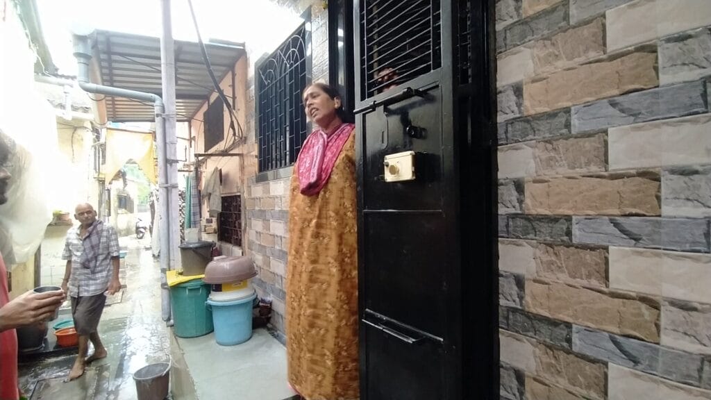 Tanubai Gore talking to the reporter as she stands outside her home.